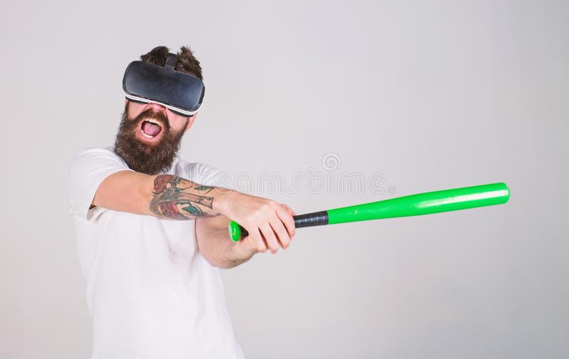 A man with a VR heaset angrily swinging a bat