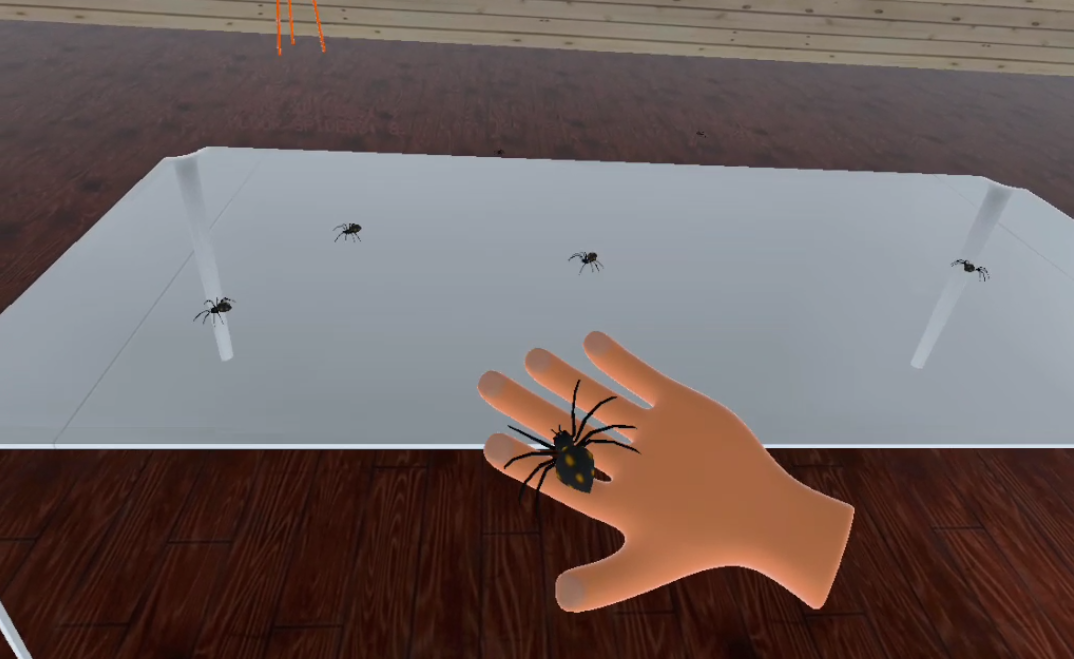 a VR scene with a first hand view of the users' hands close to a table with spiders and one spider on the hand